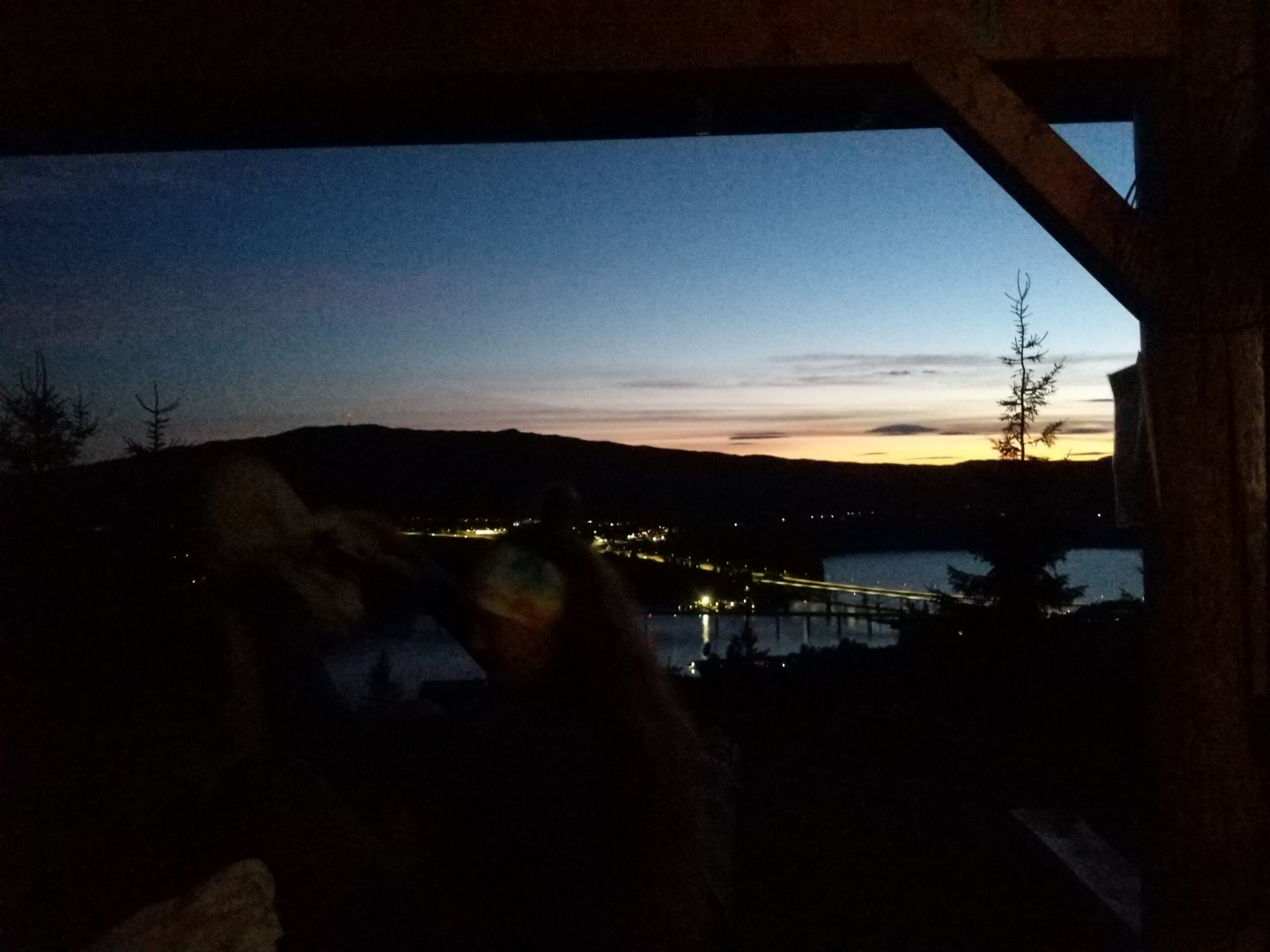 Ein Bild, dass den Sonnenuntergang aus einem Shelter in Norwegen zeigt, im Hintergrund drei Brücken über den Mjøsa.